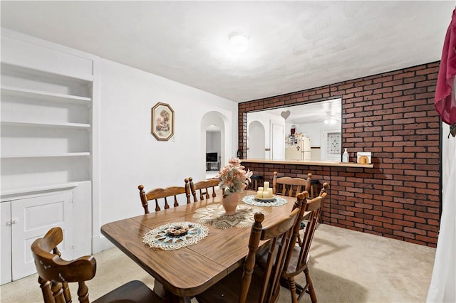 313 N Market St, Carmichaels/Cumblnd, PA 15320 - carpeted dining area with built in features, ceiling fan, arched walkways, and brick wall