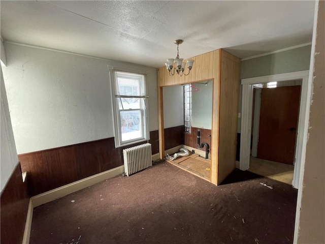846 Florence Ave, East Mckeesport, PA 15035 - interior space featuring radiator heating unit, wooden walls, a wainscoted wall, and a chandelier