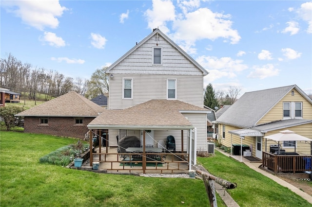 16 Elm St, Burgettstown Boro, PA 15021 - back of property featuring a shingled roof, a patio, a lawn, and central air condition unit