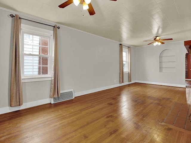 empty room featuring visible vents, hardwood / wood-style floors, and ceiling fan