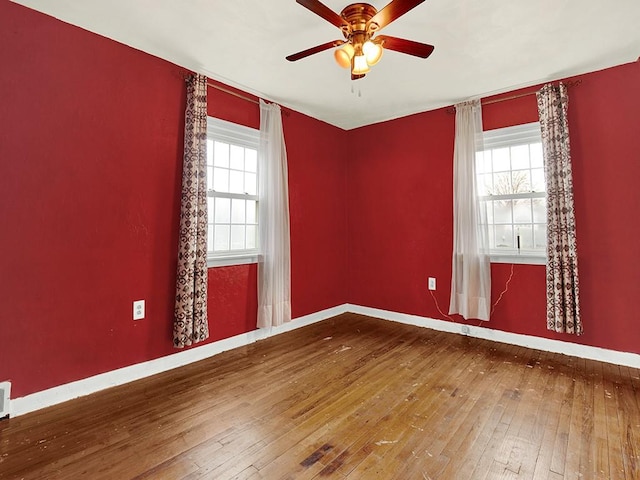 empty room with hardwood / wood-style floors, a healthy amount of sunlight, and ceiling fan