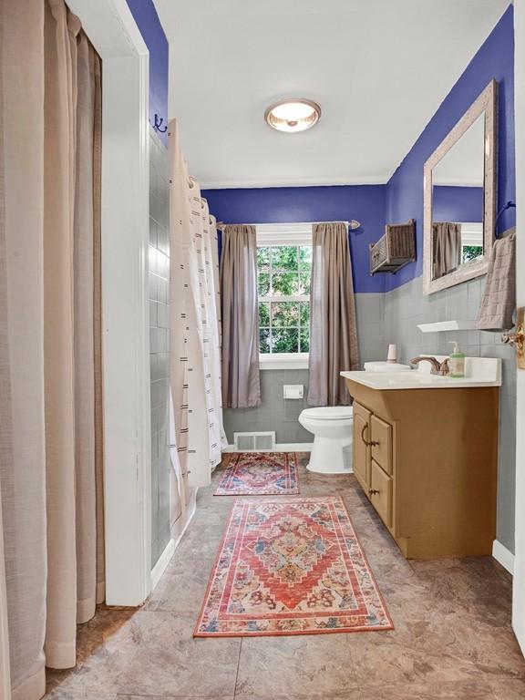 full bathroom with vanity, visible vents, and toilet