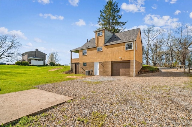 226 Old Leechburg Rd, Plum Boro, PA 15239 - view of side of property with driveway, cooling unit, brick siding, a garage, and a lawn