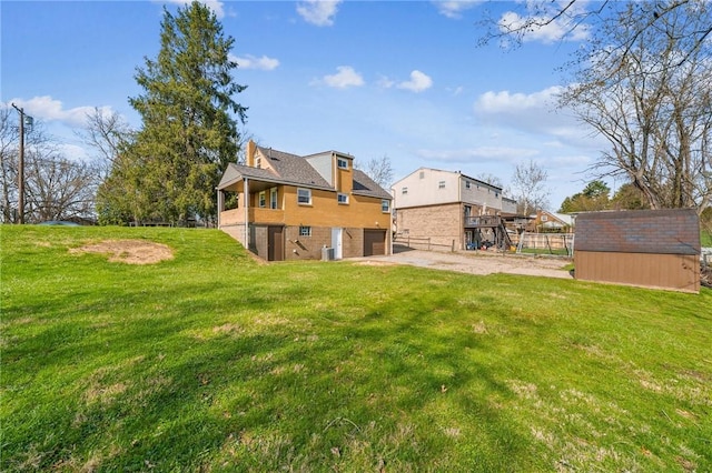 226 Old Leechburg Rd, Plum Boro, PA 15239 - back of property with driveway, an attached garage, an outbuilding, a lawn, and a storage unit