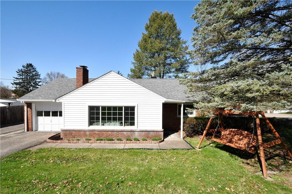 133 S Patton, Moon/Crescent Twp, PA 15108 - back of house with roof with shingles, aphalt driveway, brick siding, a garage, and a lawn