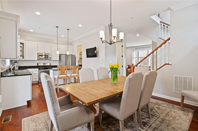 dining space with dark wood-type flooring, visible vents, and crown molding
