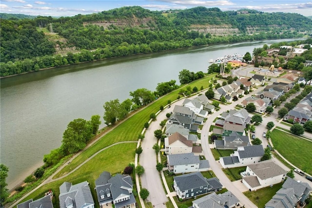 birds eye view of property with a wooded view, a residential view, and a water view