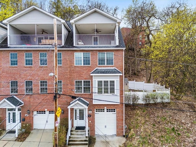 view of front of property with an attached garage, fence, concrete driveway, brick siding, and a balcony