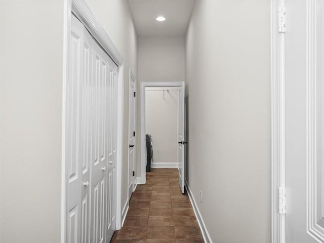 corridor with recessed lighting, dark tile patterned floors, and baseboards