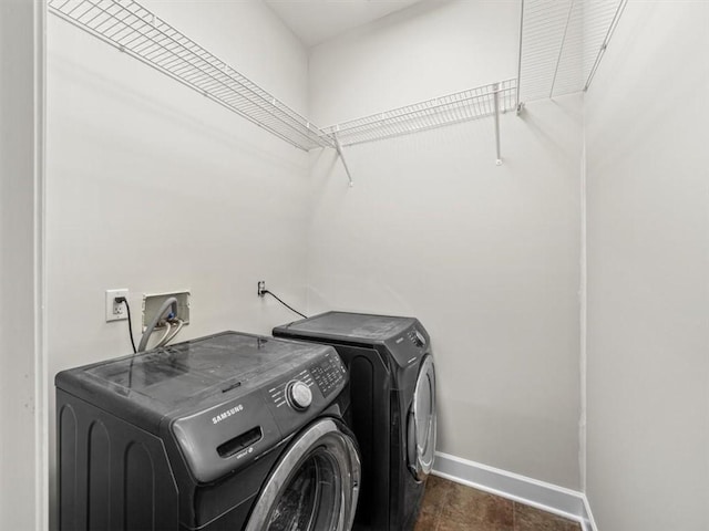 washroom with washing machine and clothes dryer, laundry area, and baseboards