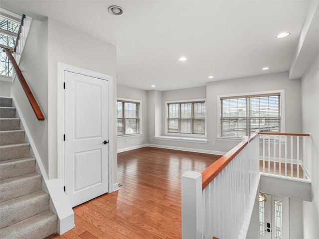 staircase with recessed lighting, baseboards, and wood finished floors