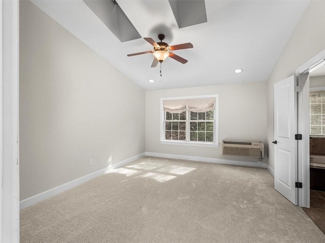 interior space featuring a wall mounted AC, carpet flooring, baseboards, and vaulted ceiling