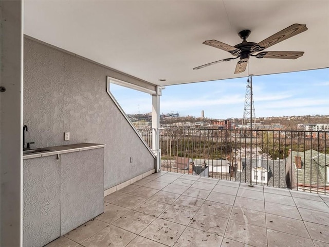 view of patio with a sink, ceiling fan, and a balcony