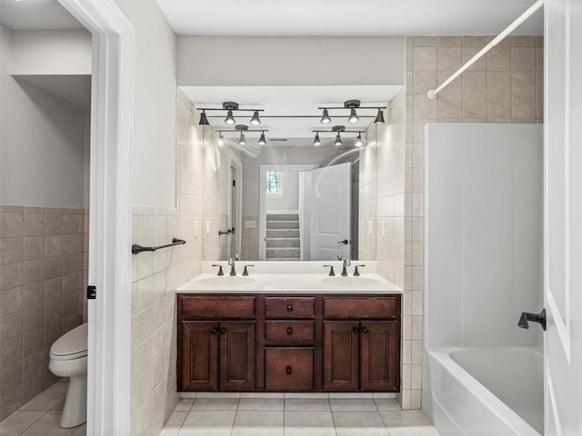 full bath featuring tile patterned flooring, tile walls, a sink, and toilet