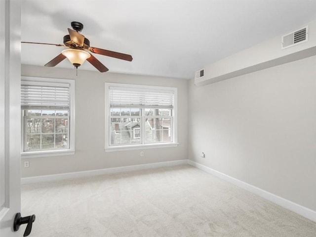 empty room with baseboards, a ceiling fan, visible vents, and carpet floors