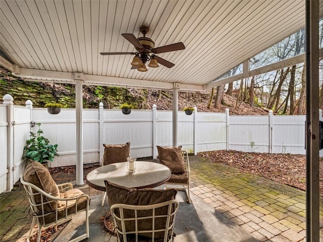 view of patio with a fenced backyard, ceiling fan, and outdoor dining area