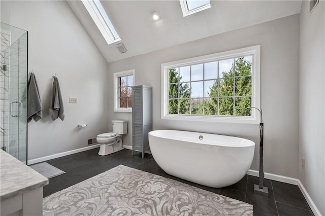 full bathroom featuring a shower stall, a freestanding bath, visible vents, and lofted ceiling with skylight