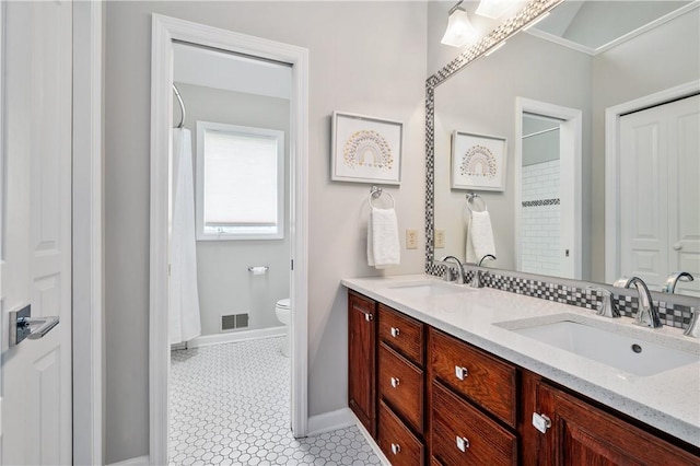 full bathroom featuring a sink, visible vents, toilet, and double vanity