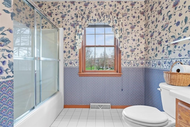 full bathroom with toilet, wallpapered walls, visible vents, and bath / shower combo with glass door