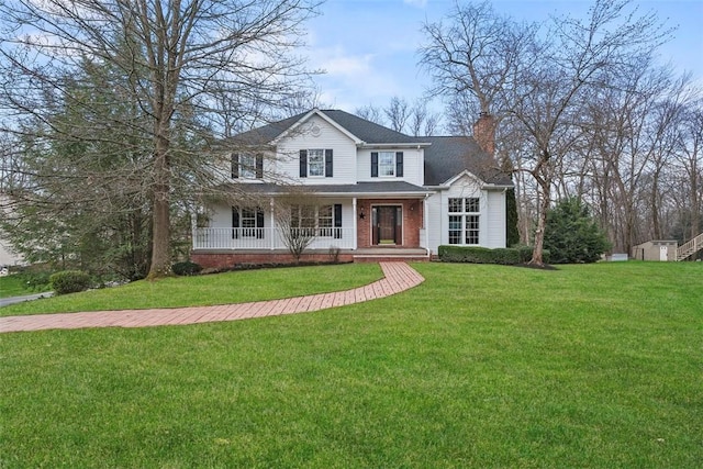 view of front facade with a chimney, covered porch, and a front lawn