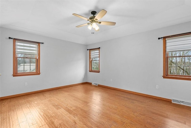 unfurnished room with baseboards, visible vents, light wood-type flooring, and a ceiling fan