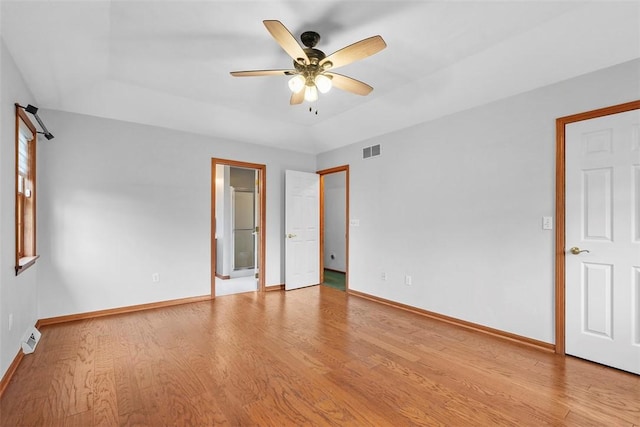 unfurnished bedroom featuring light wood-type flooring, baseboards, visible vents, and connected bathroom