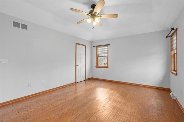 empty room with visible vents, light wood-type flooring, and a ceiling fan