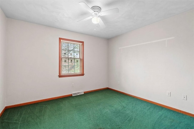 empty room with baseboards, a ceiling fan, visible vents, and carpet floors