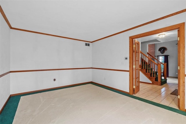 tiled spare room with visible vents, baseboards, carpet, crown molding, and stairs