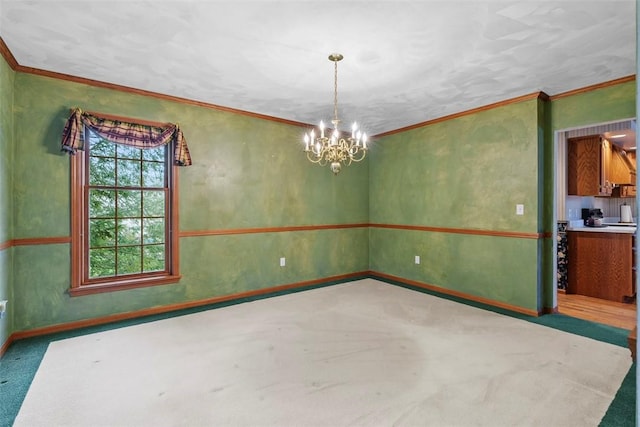 spare room with a chandelier, baseboards, and ornamental molding