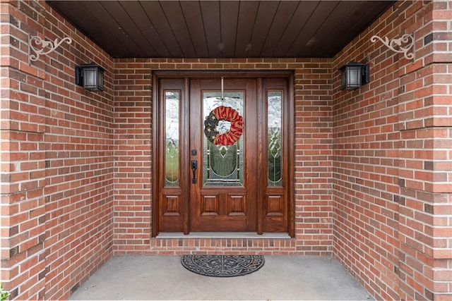 view of exterior entry featuring brick siding