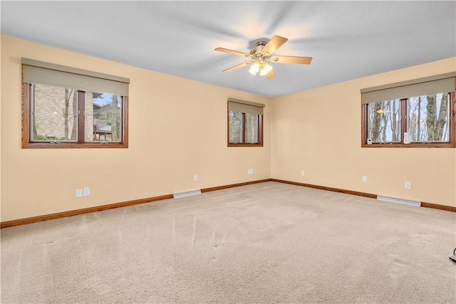carpeted empty room with visible vents, a ceiling fan, and baseboards