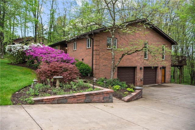 view of home's exterior with an attached garage, concrete driveway, and brick siding