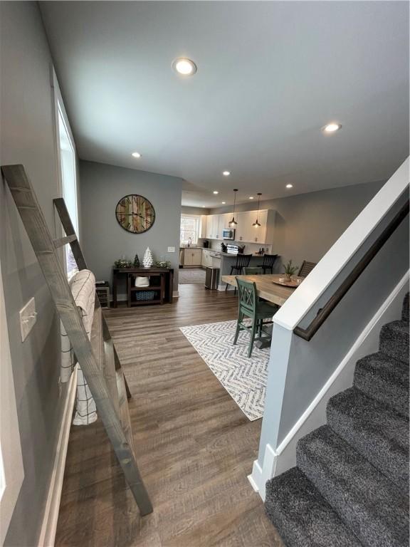 living room featuring stairway, recessed lighting, and dark wood-type flooring