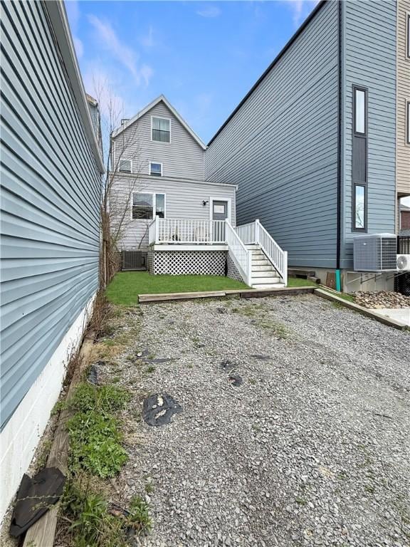 rear view of house featuring central AC unit and a deck