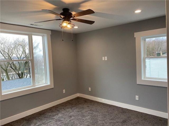 empty room featuring baseboards, recessed lighting, a ceiling fan, visible vents, and dark carpet