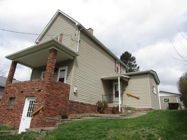 view of side of home featuring a yard and a chimney