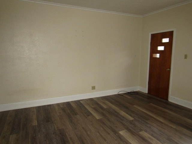 empty room featuring dark wood-type flooring, baseboards, and ornamental molding