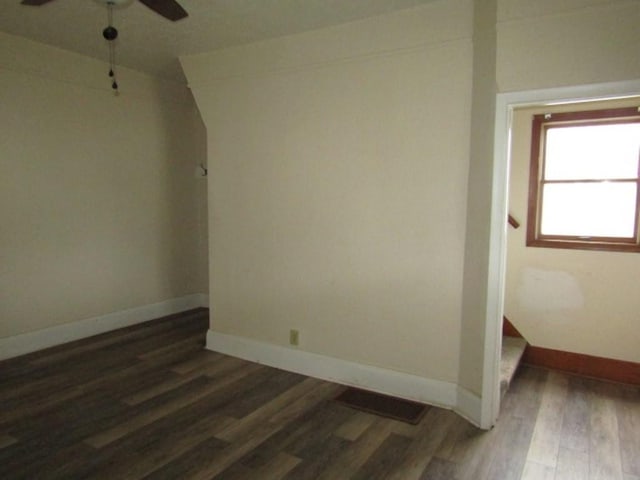 unfurnished room with baseboards, wood finished floors, and ceiling fan