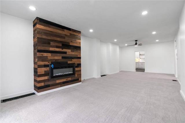 unfurnished living room featuring a large fireplace, a ceiling fan, carpet, and recessed lighting