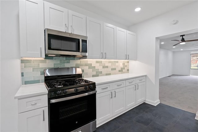 kitchen featuring white cabinetry, dark carpet, tasteful backsplash, and appliances with stainless steel finishes