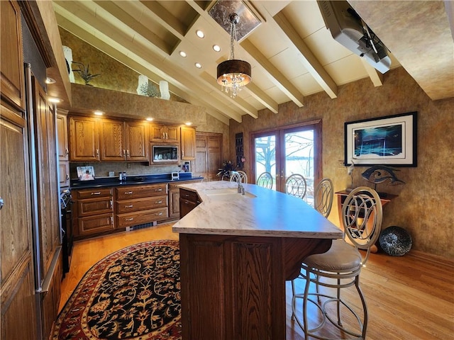 288 Latonka Dr, Jackson Twp Mer, PA 16137 - kitchen with light wood finished floors, black microwave, a sink, brown cabinets, and a breakfast bar