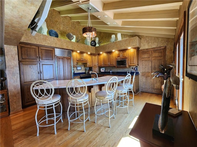 288 Latonka Dr, Jackson Twp Mer, PA 16137 - kitchen featuring built in appliances, brown cabinets, light wood-style floors, beamed ceiling, and a large island