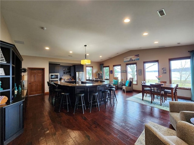 288 Latonka Dr, Jackson Twp Mer, PA 16137 - kitchen featuring vaulted ceiling, a breakfast bar, dark wood-style flooring, healthy amount of natural light, and a large island