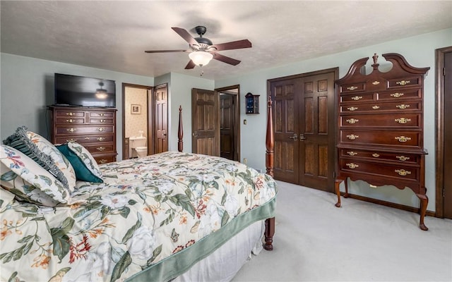 bedroom featuring light colored carpet, ceiling fan, and connected bathroom