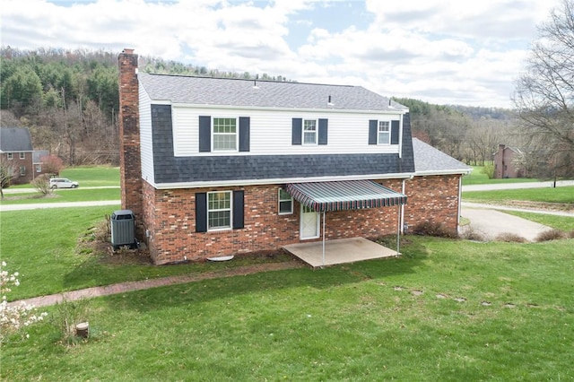 view of front of home featuring roof with shingles, a front lawn, and brick siding