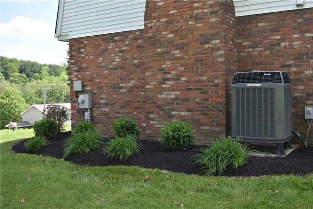 511 Pleasant Valley Rd, Buffalo Twp Wsh, PA 15301 - exterior view of central air condition unit, electric meter, brick siding, and a wood stove