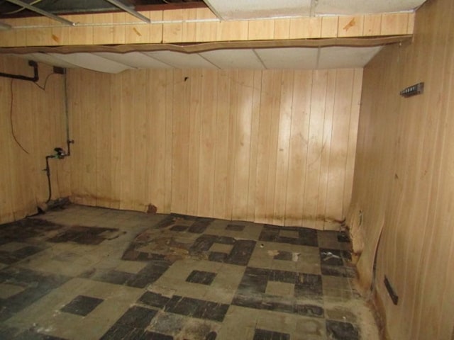 below grade area featuring wood walls and tile patterned floors