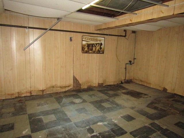 finished basement featuring wood walls and tile patterned floors