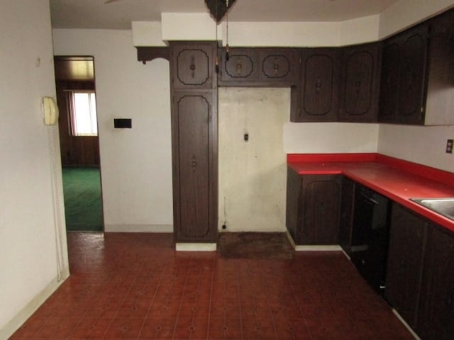 kitchen featuring baseboards and dark brown cabinetry